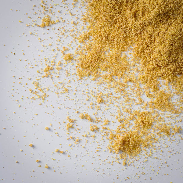 true cold milled golden flax scattered on a light gray background