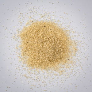 Pile of Premium Gold Brand whole white fonio on a white background