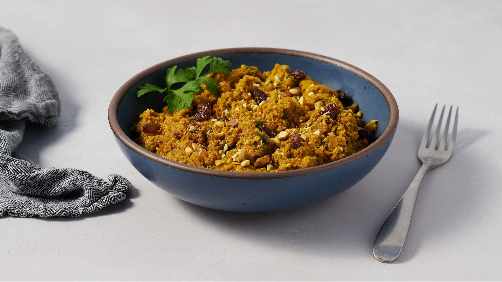 Savory curried fonio bowl with dried cranberries and crushed almonds